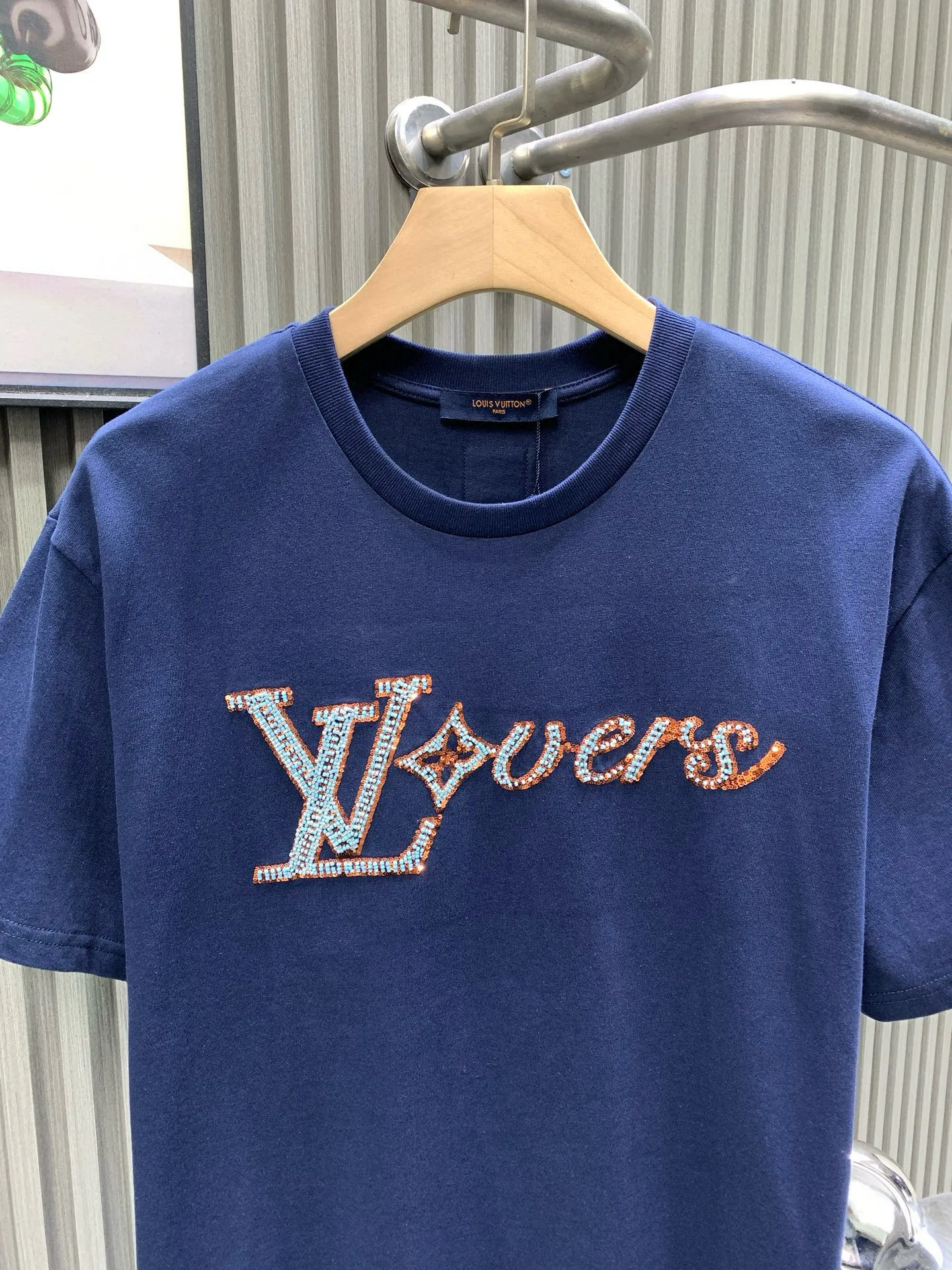 🅿️240 🀄️ Louis Vuitton 1V 2025 new hand-beaded embroidered short-sleeved T-shirt 40S pure cotton plain 100% cotton fabric 280g This T-shirt is made of soft cotton and uses beaded embroidery to express the 1V Lovers logo. It can inject an elegant atmosphere into daily looks. The fabric has good breathability and sweat permeability and can absorb sweat and micro-perspiration from human skin. It is more comfortable to wear in summer without sticking to the human body, and truly achieves breathable and sweat-absorbing effects. Sequin embroidery is also called bead embroidery or sequin embroidery. It is a type of embroidery machine. Materials with a hard texture, flat surface and high smoothness are selected to place the sequins on the fabric in the specified direction. At the same time, the embroidery needle pierces the fabric at the center of the sequins to fix the position of the sequins. The beaded part has a protruding three-dimensional surface, forming a full, embossed and undulating effect. The three-dimensional texture beads that add patterns are dyed with the original color to create a gradient beading effect. The color effect is saturated and bright, covering the entire surface and achieving the original effect. The number of particles is clear, and the overall three-dimensional effect is outstanding.
